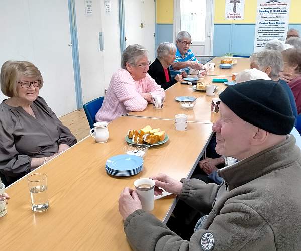 A group of people meeting at Upper Studley Baptist Church Hall, eating cake and drinking Tea.